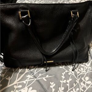 Rebecca Minkoff black leather handbag with fringe details.